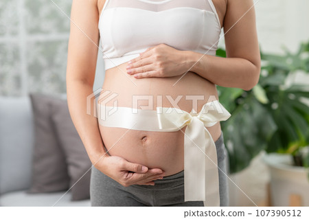 Close up Pregnant Woman standing in front of windows and stroking her big belly with love at cozy home,Pregnancy of young woman enjoy with future life relax with love,Motherhood and Pregnant Concept Close up Pregnant Woman standing in front of windows and stroking her big belly with love at cozy home,Pregnancy of young woman enjoy with future life relax with love,Motherhood and Pregnant Concept 107390512