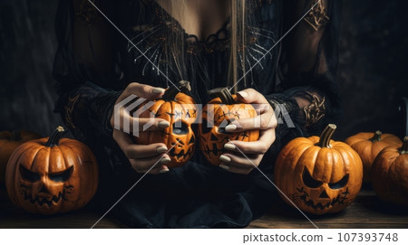 Woman's hands and Halloween pumpkins 107393748