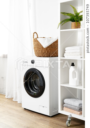 Laundry room with washing machine and basket with laundry Laundry room with washing machine and basket with laundry 107393749