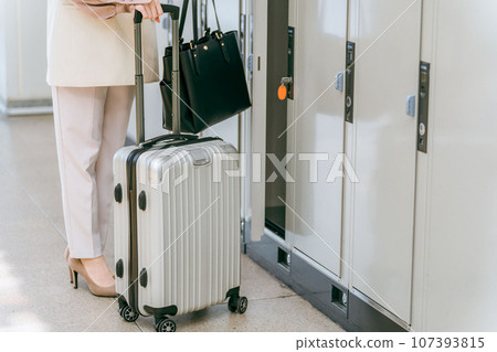一位女士將行李寄存在車站或商業設施的投幣式儲物櫃中(海外旅行、隨身攜帶的包包、櫃子) 一位女士將行李寄存在車站或商業設施的投幣式儲物櫃中(海外旅行、隨身攜帶的包包、櫃子) 107393815