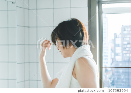 Getting ready in the morning: Portrait of a woman in the bathroom 107393994