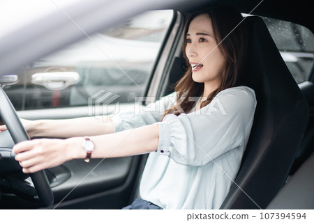 Young woman surprised by danger while driving 107394594