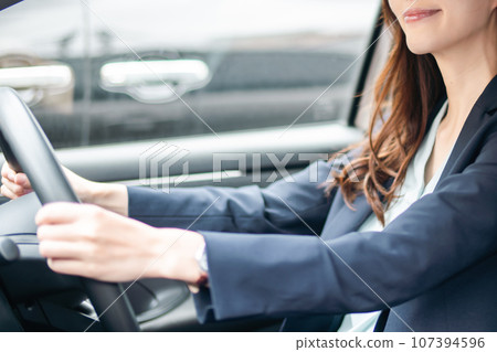Young woman with glasses driving in a jacket, faceless 107394596