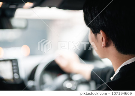 Young man driving a car, faceless 107394609