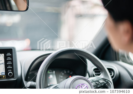 Young man driving a car, faceless 107394610