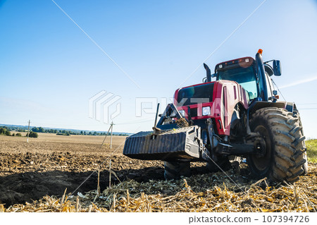Tractor in the field. Agricultural machinery. Agricultural farm tractor during tillage of soil and field after harvest. Tractor in the field. Agricultural machinery. Agricultural farm tractor during tillage of soil and field after harvest. 107394726