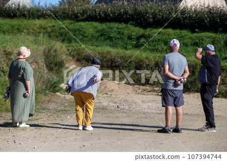 Senior petanque players during a game 107394744