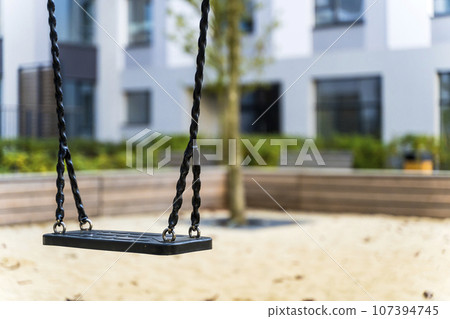 Swings on playground. Modern safe swing in a public park Swings on playground. Modern safe swing in a public park 107394745