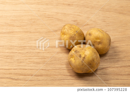 三個馬鈴薯放在木板上“留空” 三個馬鈴薯放在木板上“留空” 107395228