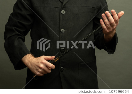 male dominant holds a leather whip Flogger for hard BDSM sex with spanking 107396664