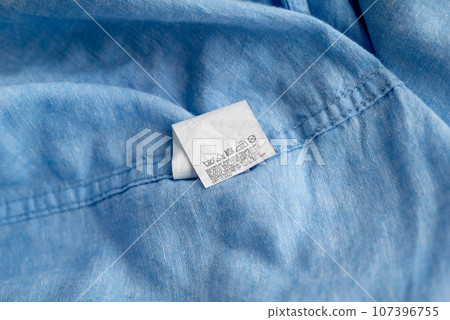 Clothing label on light blue garment, top view Clothing label on light blue garment, top view 107396755