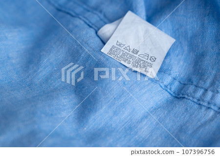 Clothing label on light blue garment, top view Clothing label on light blue garment, top view 107396756