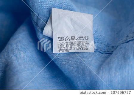 Clothing label on light blue garment, top view 107396757