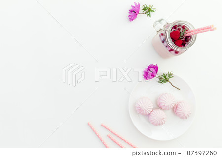 Trasty smoothie with straws, sweet marshmallow and anemones flowers on white background. Flat lay. 107397260