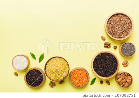 Various superfoods in smal bowl on colored background. Superfood as rice, chia, quinoa, lentils, nuts, sesame seeds, almonds. top view copy space 107398751