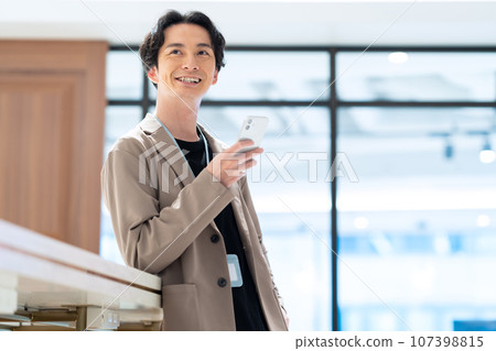 Engineer operating a smartphone in the office Photography cooperation: WEEK Shiba Daimon (Sun Frontier Real Estate) 107398815