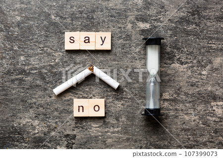 Cigarette And Wooden Blocks, Broken cigarette on table background with hourglass, No Tobacco Day with hourglass, clock health concept. time to quit smoking Cigarette And Wooden Blocks, Broken cigarette on table background with hourglass, No Tobacco Day with hourglass, clock health concept. time to quit smoking 107399073