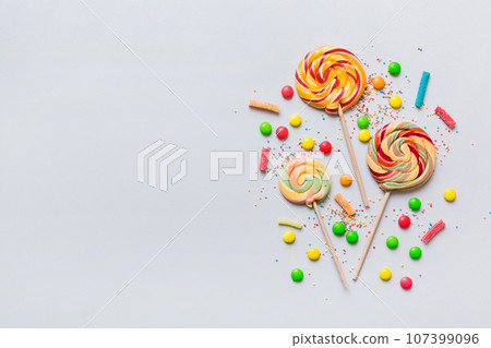 Tasty appetizing Party Accessories Happy Birthday Sweet. Different types of candies on colored background, copy space. Colorful birthday party background Tasty appetizing Party Accessories Happy Birthday Sweet. Different types of candies on colored background, copy space. Colorful birthday party background 107399096