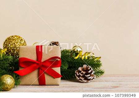 New Year Christmas mood, gift box, branches of a christmas tree, New Year decorations on a colored background New Year Christmas mood, gift box, branches of a christmas tree, New Year decorations on a colored background 107399349