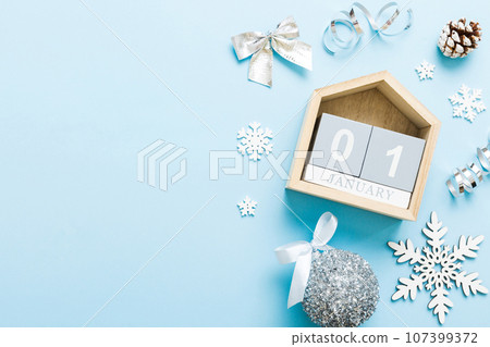 Christmas calendar 1 january. Christmas gift, fir branches, pine cones. Flat lay, top view. New Year decorations on a colored background Christmas calendar 1 january. Christmas gift, fir branches, pine cones. Flat lay, top view. New Year decorations on a colored background 107399372