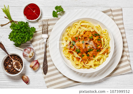 Creamy Paprika Pork Chunks over tagliatelle noodle 107399552