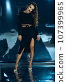 Sexy fashionable lady in black dress posing in studio on dark foil background 107399965