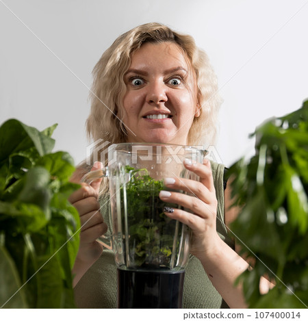 Young woman with a set of green Ingredients lettuce, spinach for a healthy diet 107400014