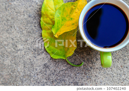 cup of coffee with autumn leaves on cement floor cup of coffee with autumn leaves on cement floor 107402240