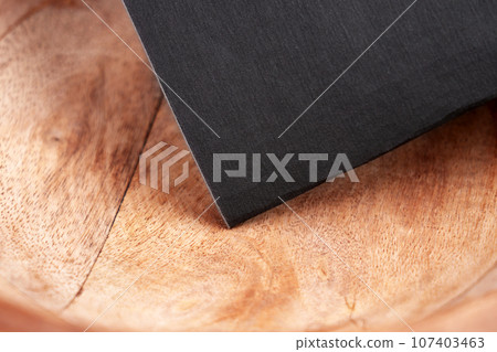 Fine-grit soft sandpaper on an old wooden work surface  107403463