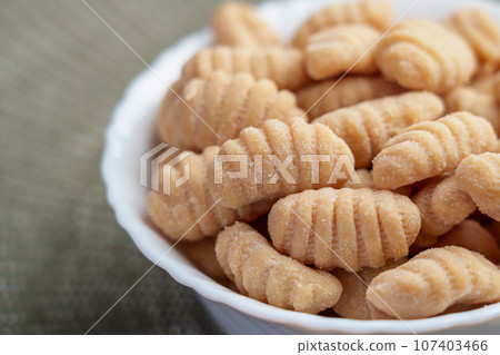 Italian raw gnocchi dumplings in white bowl. Gluten free product with potatoes and rice flour 107403466