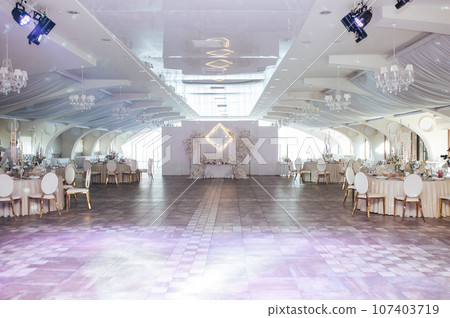 Luxurious restaurant. Luxurious interior, white tables, serving dishes and glasses for guests 107403719