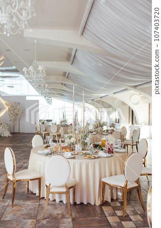 Luxurious restaurant. Luxurious interior, white tables, serving dishes and glasses for guests 107403720