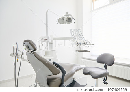 Dentist's office interior with modern chair and special dentisd equipment. Dentist office. Dentist chair in high class dental clinic. Dentist office. Medical concept. Dentist's office interior with modern chair and special dentisd equipment. Dentist office. Dentist chair in high class dental clinic. Dentist office. Medical concept. 107404539