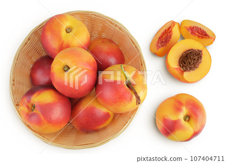 Ripe nectarine fruit with half in a wicker basket isolated on white background with full depth of field. Top view. Flat lay 107404711