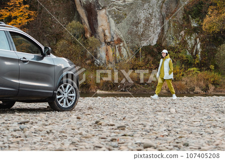 happy woman at rocky beach near suv car road trip concept happy woman at rocky beach near suv car road trip concept 107405208