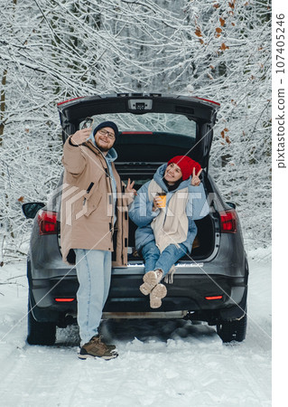 When a couple stops to eat in a snowy forest to take a break from the road, they take a selfie 107405246
