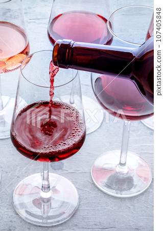 Red wine pour into a glass at a tasting. Rose, red, and white wine, drinks Red wine pour into a glass at a tasting. Rose, red, and white wine, drinks 107405848