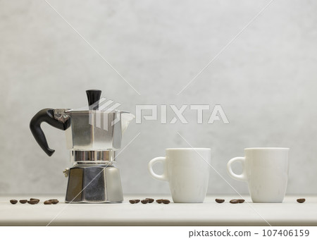 Metal geyser coffee maker on table with cup 107406159