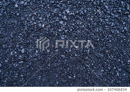 Dark pebbles as a background. Round stones on the beach.  107406834