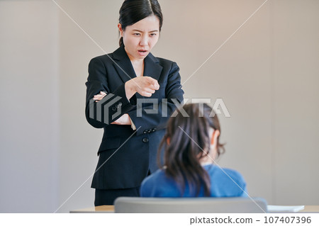Female teacher scolding a girl with folded arms Female teacher scolding a girl with folded arms 107407396