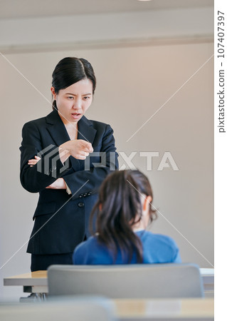 Female teacher scolding a girl with folded arms Female teacher scolding a girl with folded arms 107407397