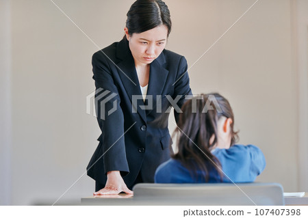 female teacher scolding a girl 107407398