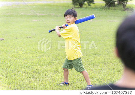 young child playing baseball in the park young child playing baseball in the park 107407557