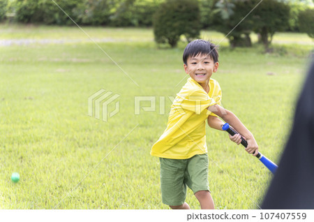 young child playing baseball in the park young child playing baseball in the park 107407559