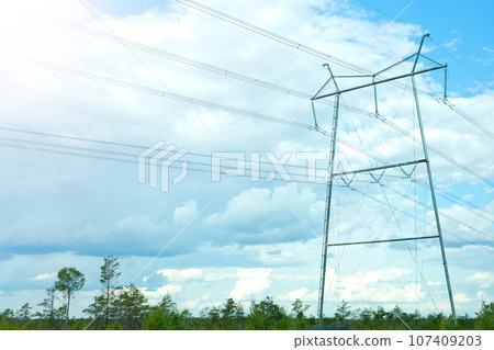 electricity lines on blue sky background. high-voltage power lines on transmission tower, energy voltage and sun shining. electric industry banner electricity lines on blue sky background. high-voltage power lines on transmission tower, energy voltage and sun shining. electric industry banner 107409203