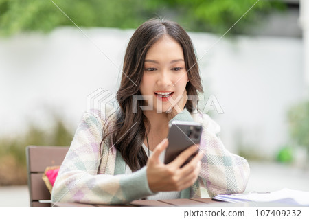 Happiness Entrepreneur beautiful business asian young woman wear casual use mobile phone for shopping online enjoy with social media and laptop at home.Small Business Startup.online banking 107409232