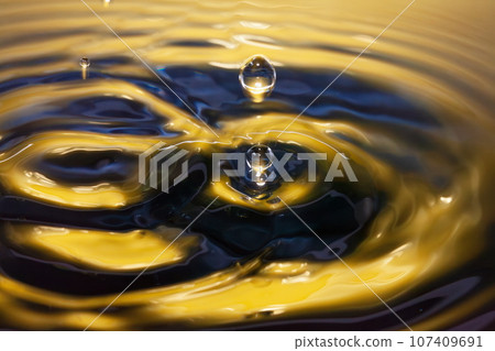 Formation of ripples and drops spreading on the water surface 107409691