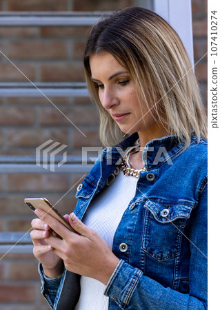 Stylish Millennial Woman with Smartphone on Stairs Stylish Millennial Woman with Smartphone on Stairs 107410274