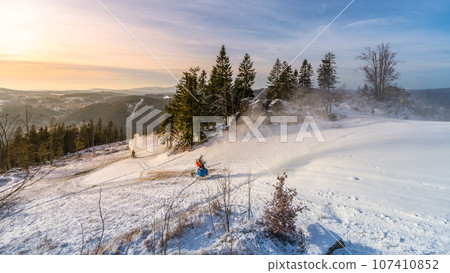 Snowmaking in the mountains in early winter. Tanvaldsky Spicak ski resort in Jizera Mountains, Czech Republic 107410852
