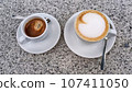 Coffee break, a couple cups of hot espresso and cappuccino drinks, outdoors, a granite background 107411050